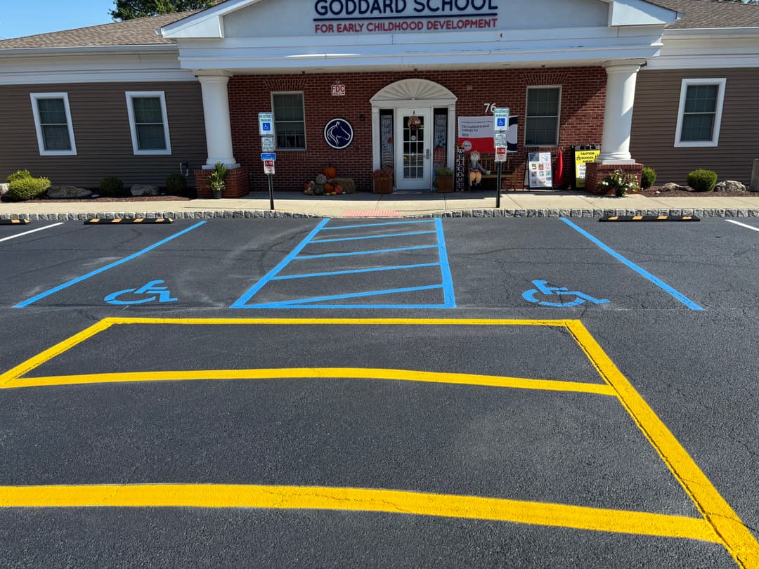 Goddard School entrance with accessible parking spaces and fall decorations.