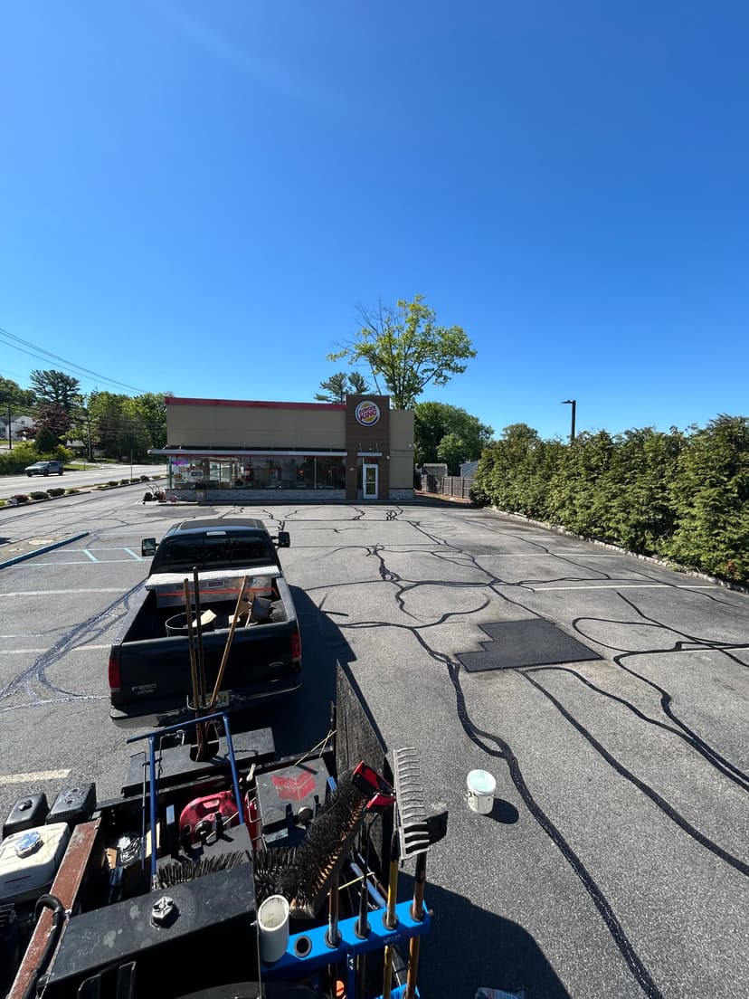 Burger King restaurant exterior with a freshly paved parking lot and clear blue sky.
