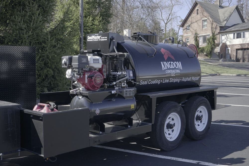 Kingdom Contracting seal coating trailer with engine and equipment for asphalt repair.