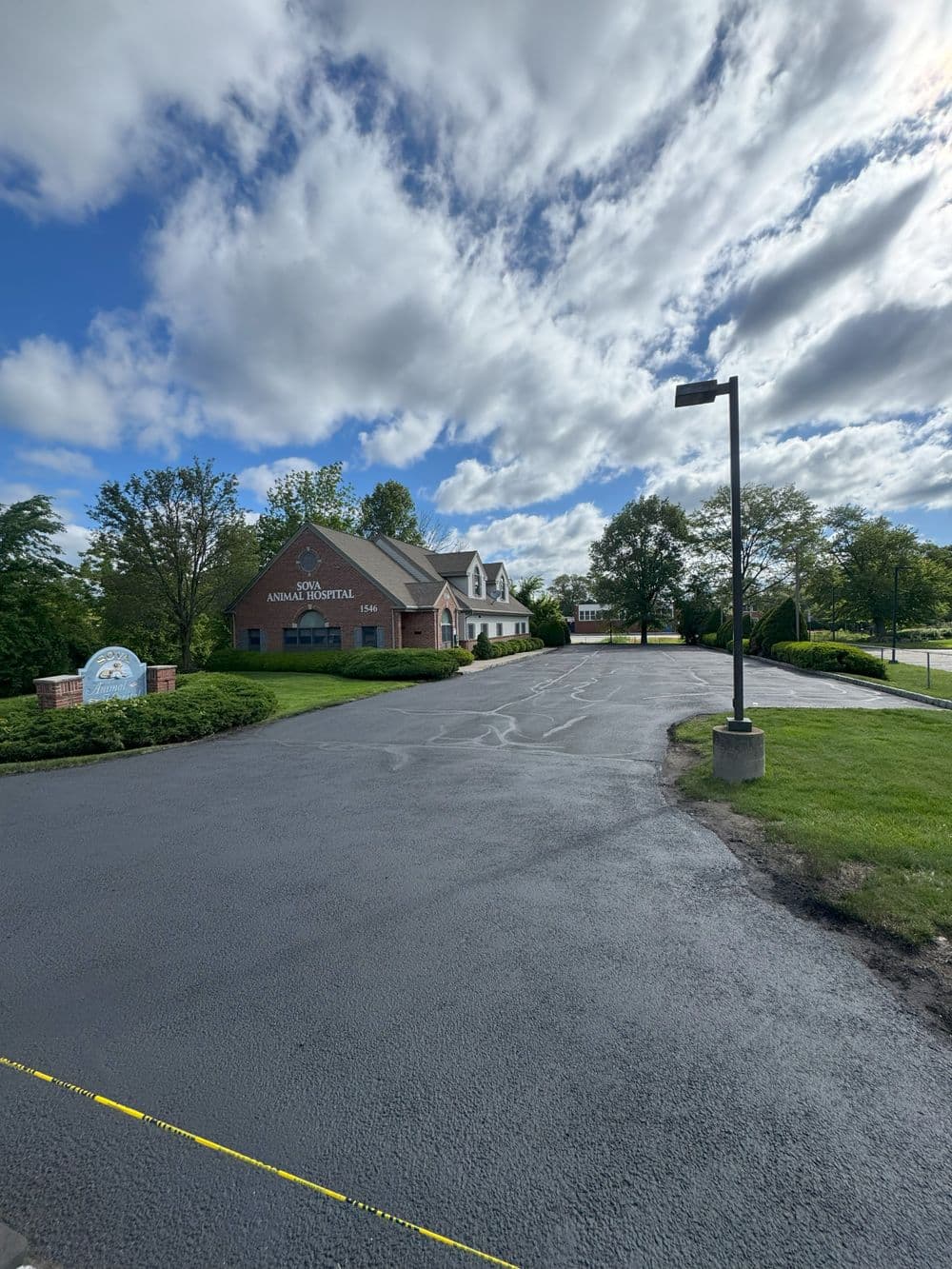 Animal hospital building with a clear sky and landscaped entrance road.
